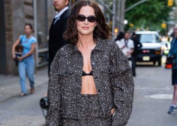 Zoey Deutch’s Chic Bra-Top Teasingly Peeks Out From Her Shiny Jacket